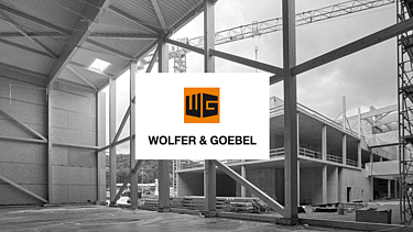 Rohbau einer Industriehalle mit Stahlkonstruktion und Wolfer & Goebel Logo